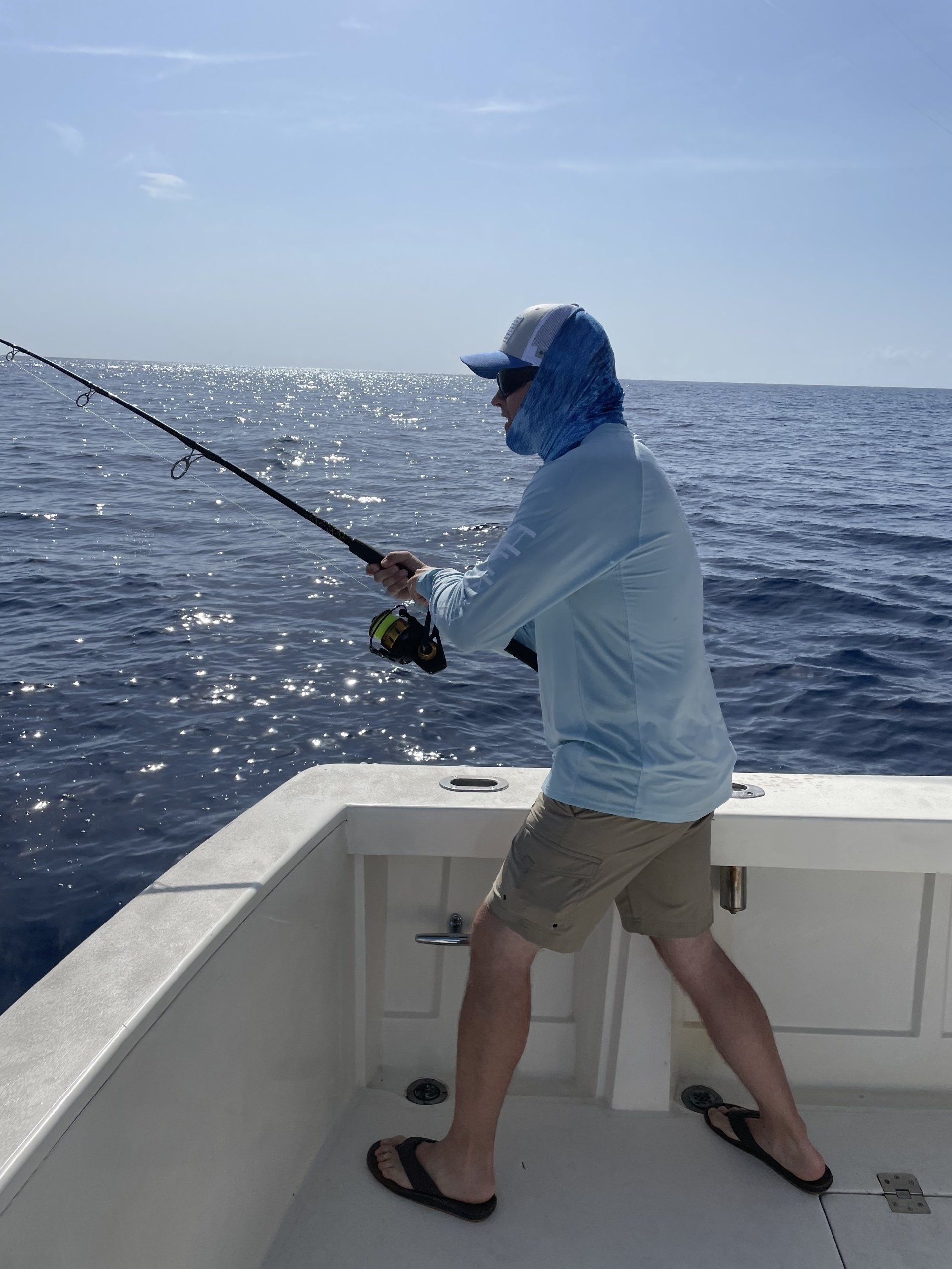 A man is fishing on a boat in the ocean