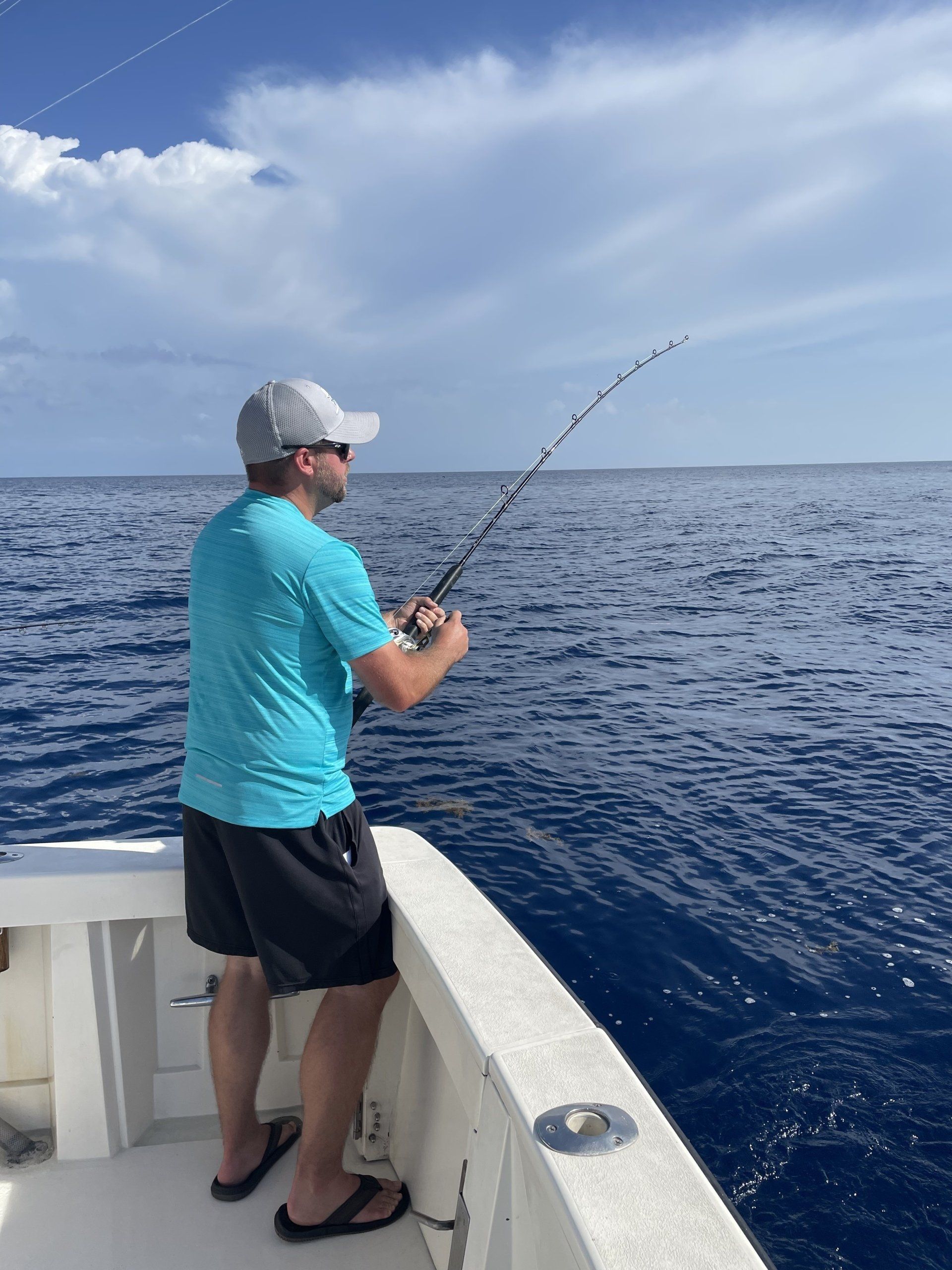 A man is fishing on a boat in the ocean