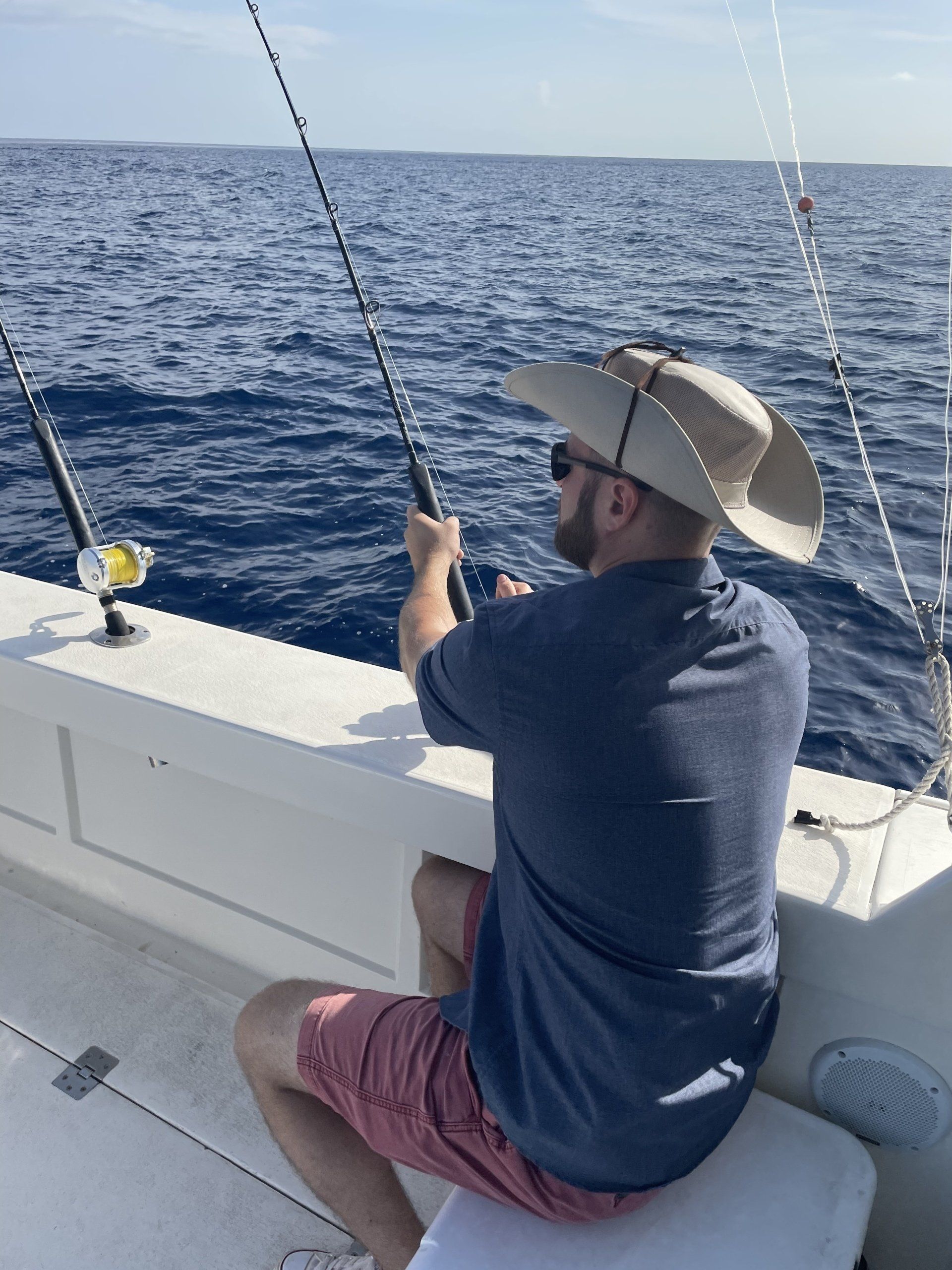 A man in a cowboy hat is fishing on a boat
