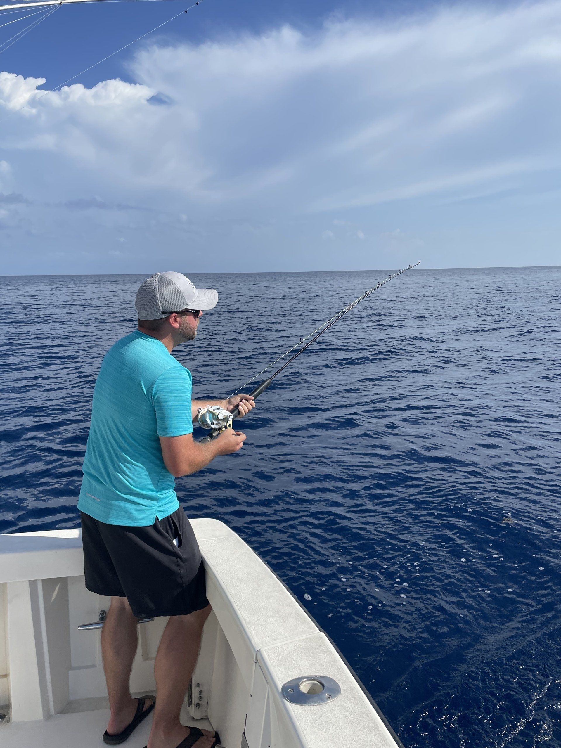 A man is fishing on a boat in the ocean