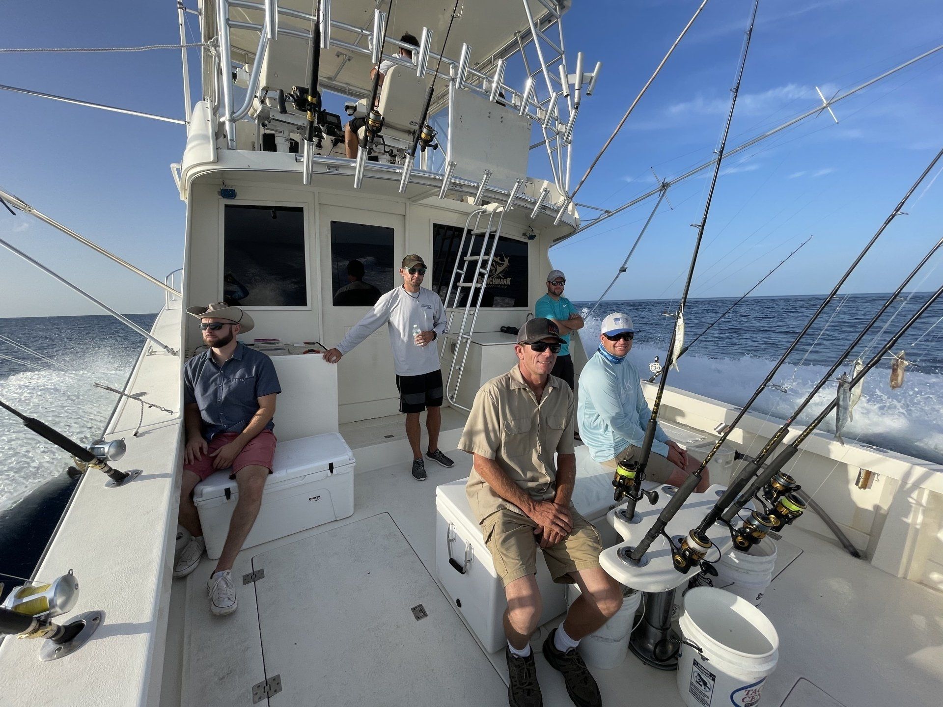 A group of men are fishing on a boat in the ocean.