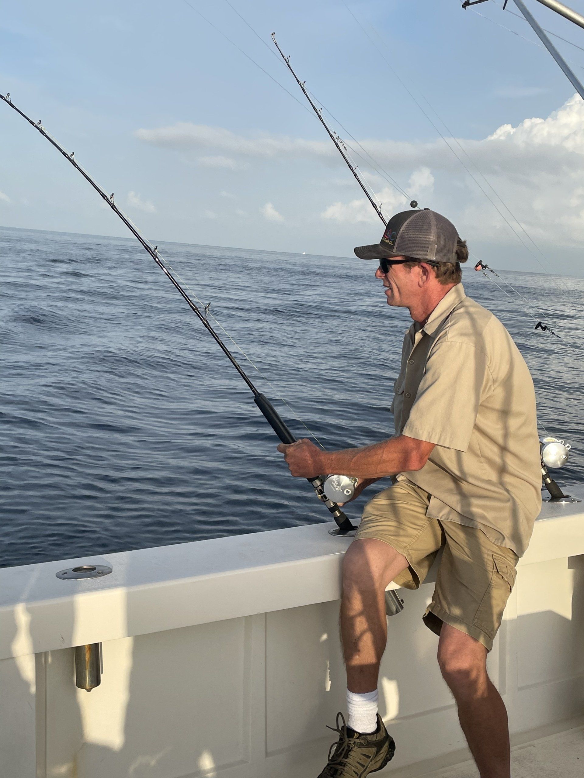 A man is fishing on a boat in the ocean