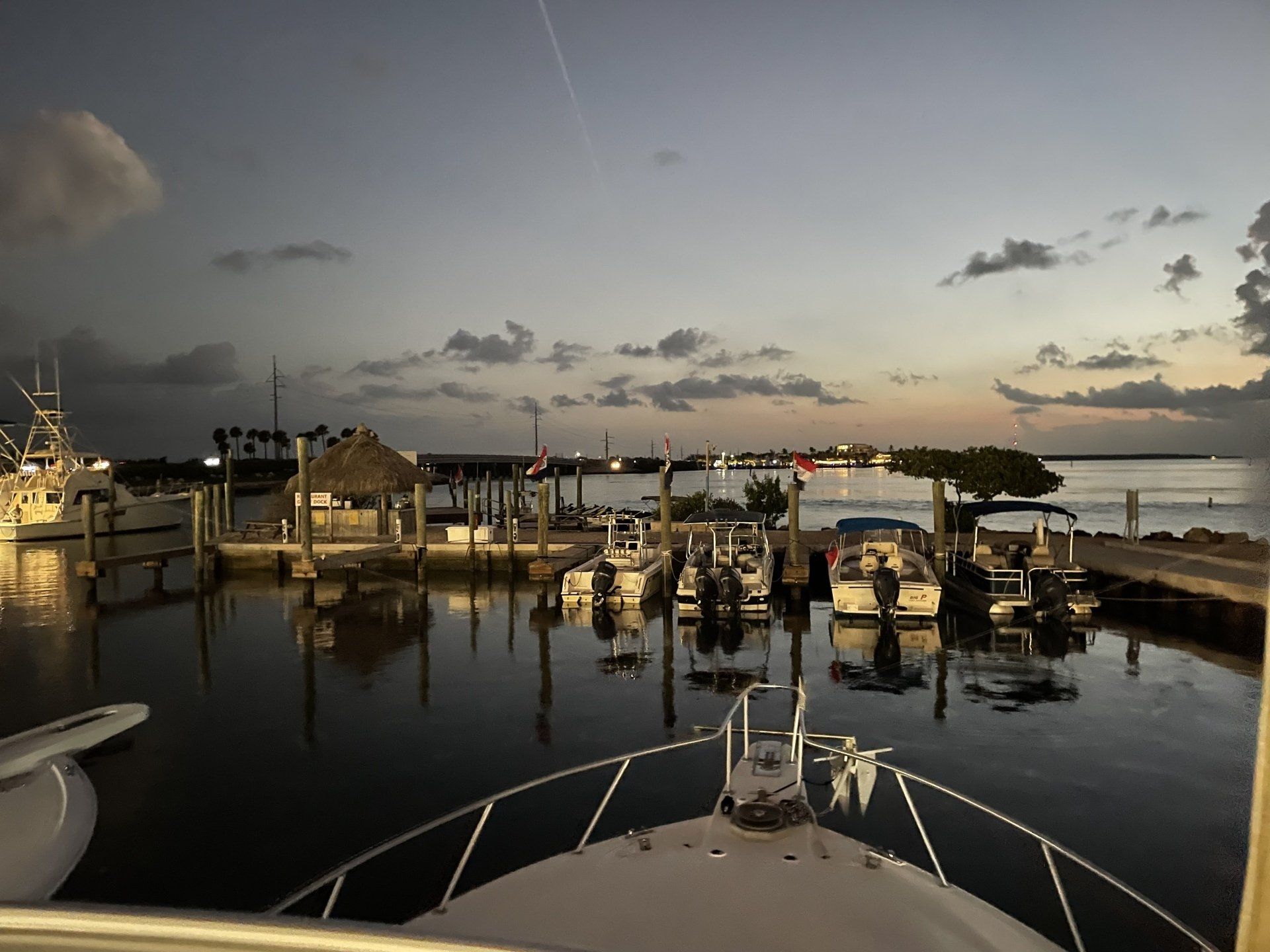 A boat is docked in a marina at sunset.