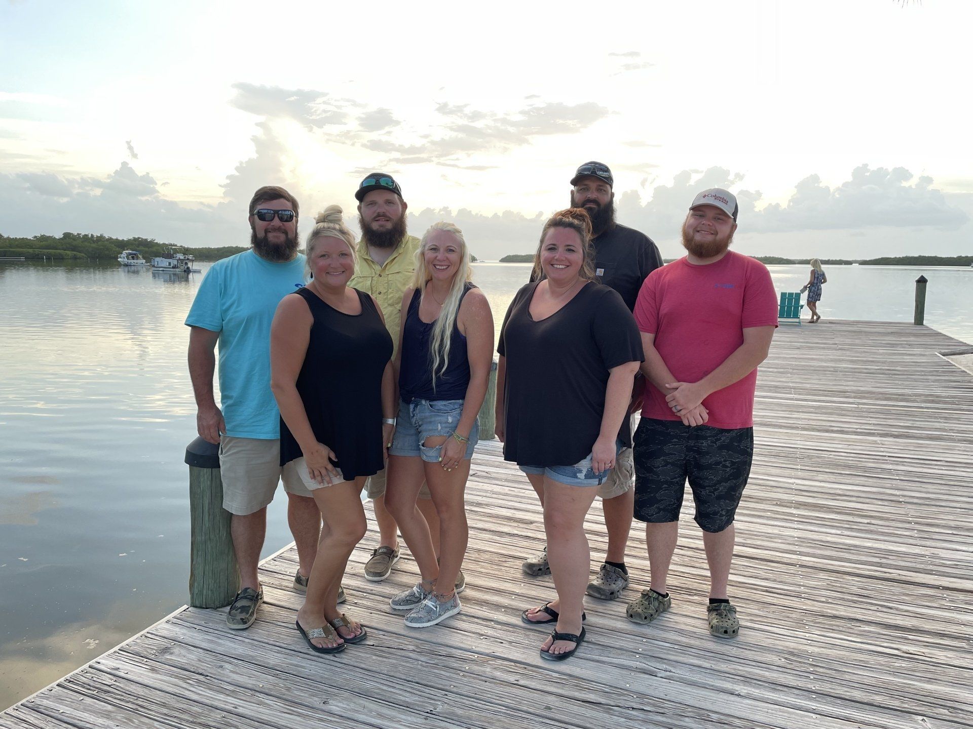 A group of people are posing for a picture on a dock.