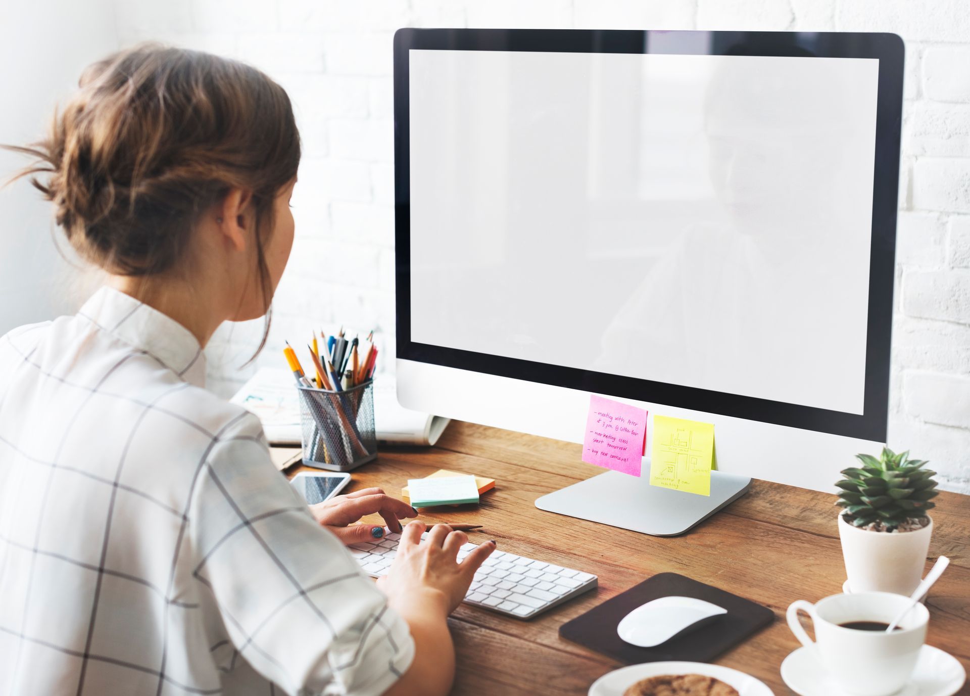 A woman is sitting at a desk working on a computer.