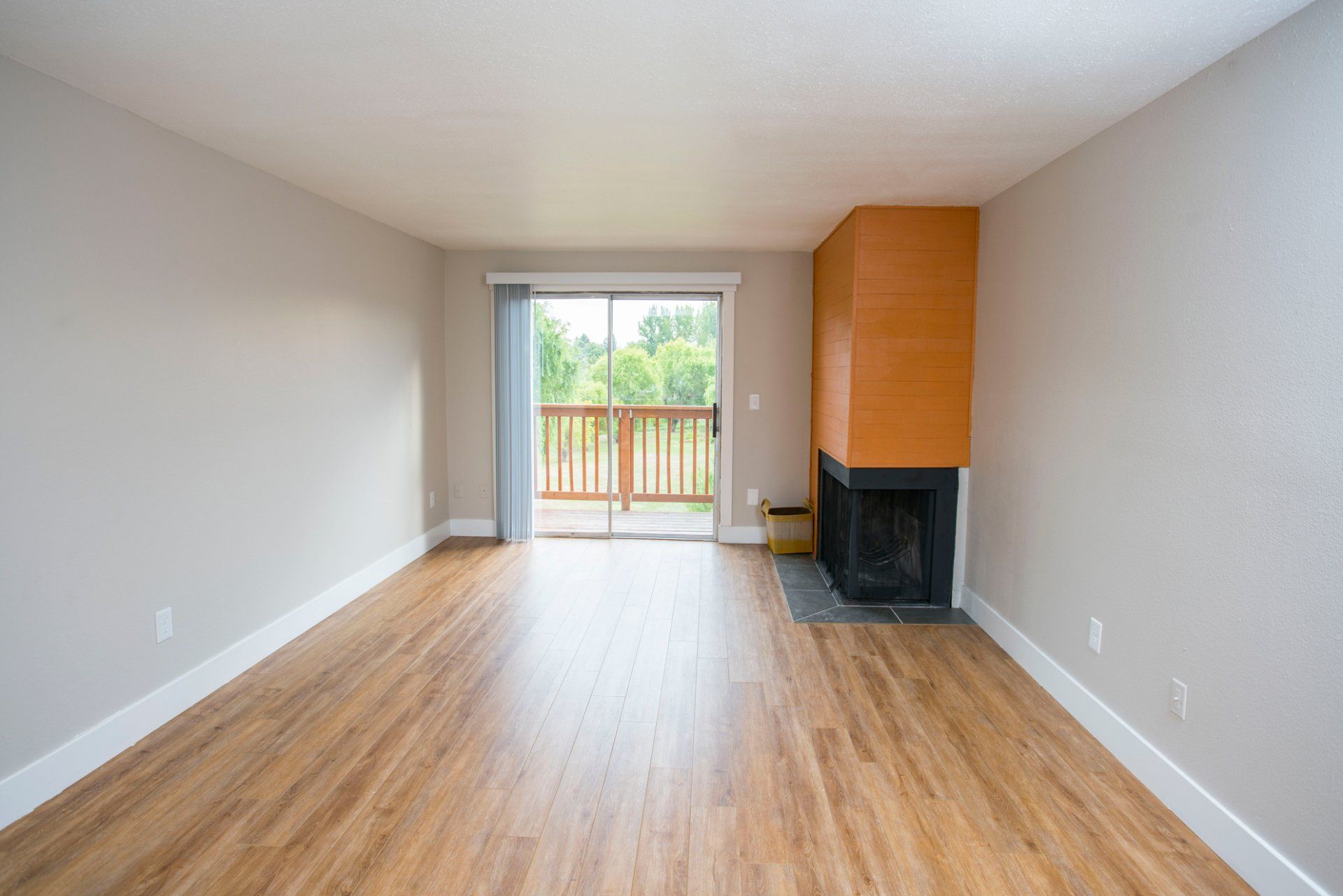 Interior of empty living room with wood flooring and a fireplace