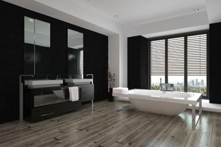 Black bathroom with white bathtub near the window