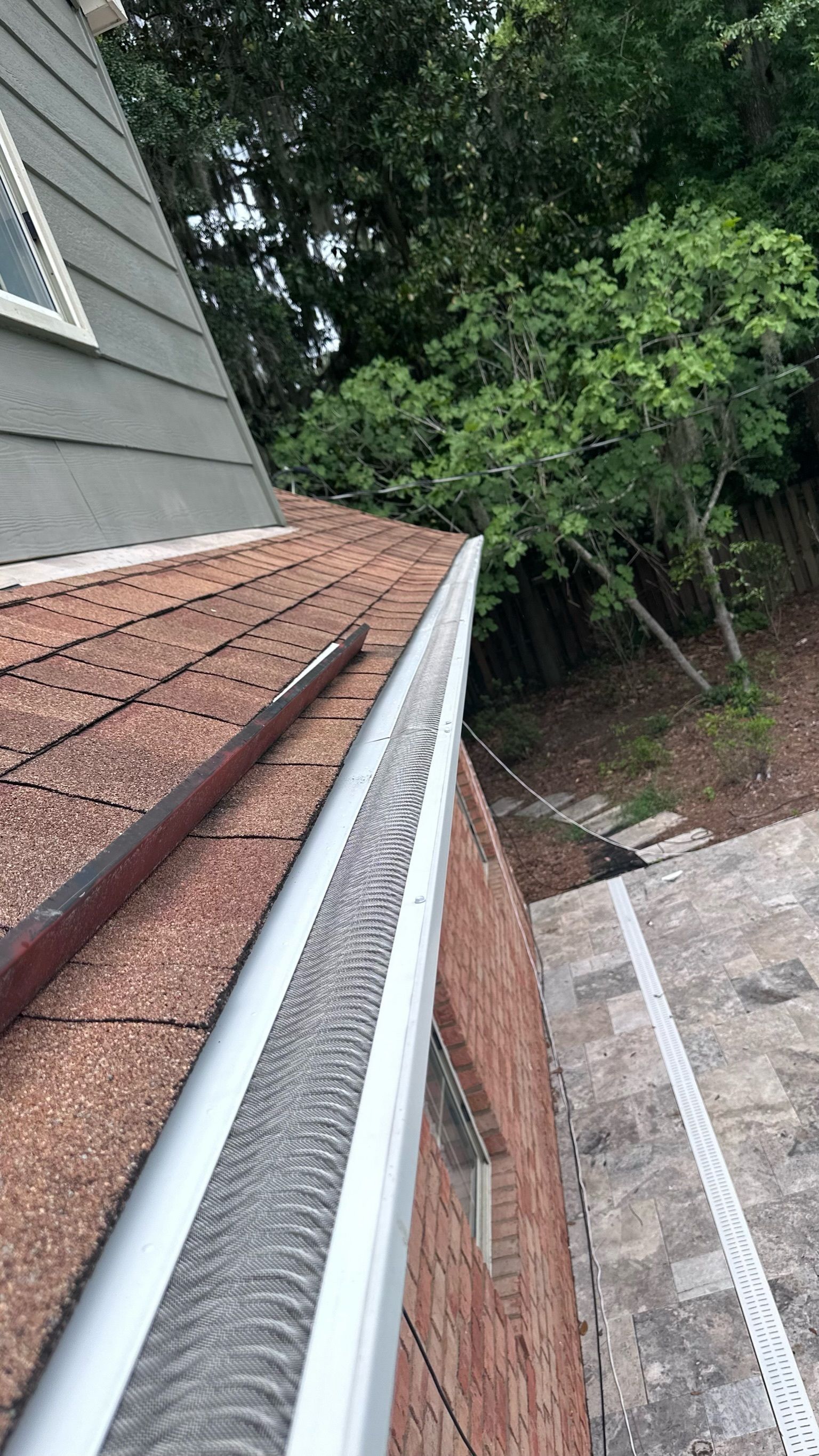 A close up of a gutter on the side of a house.