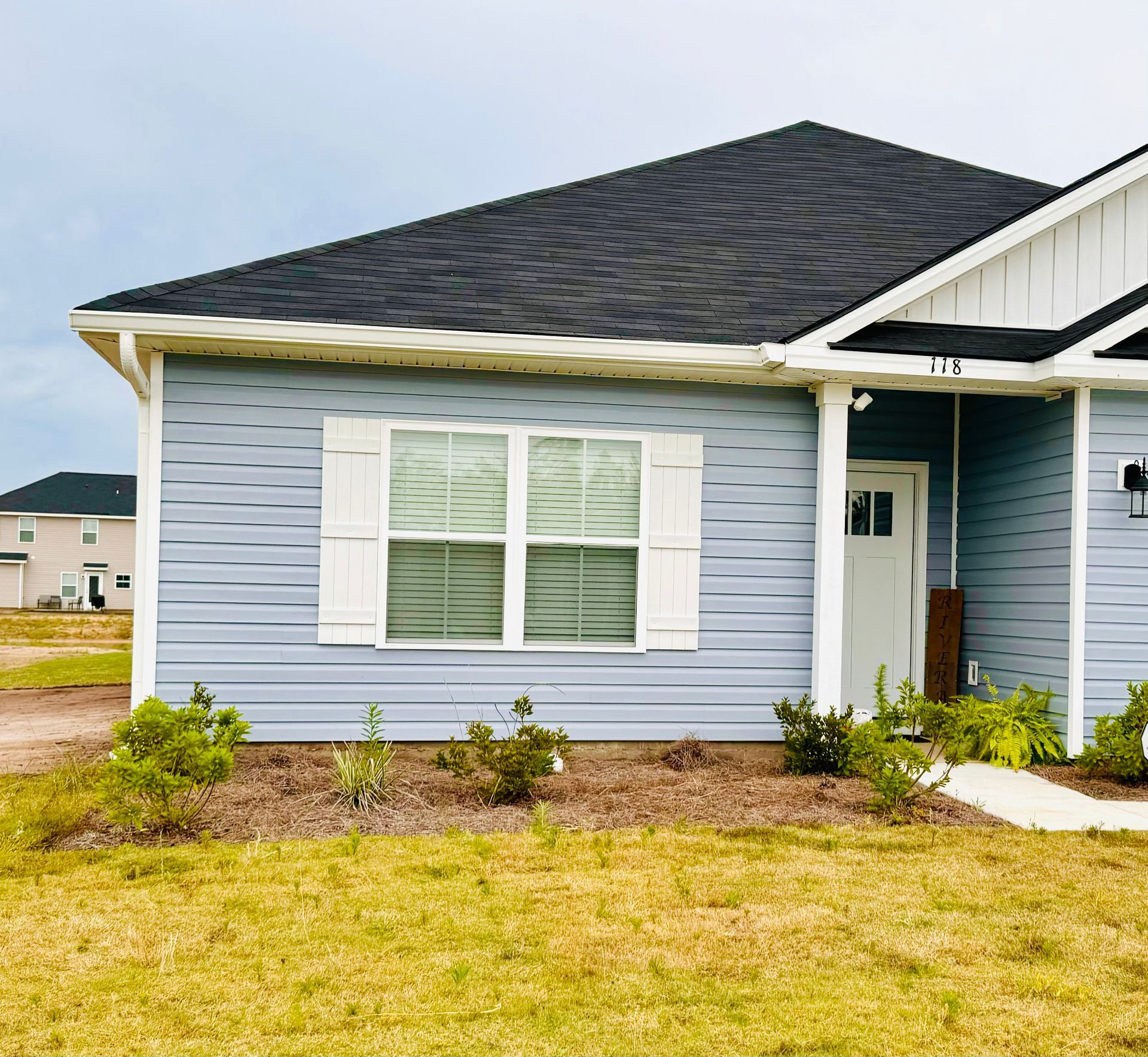 A blue house with a black roof and white shutters