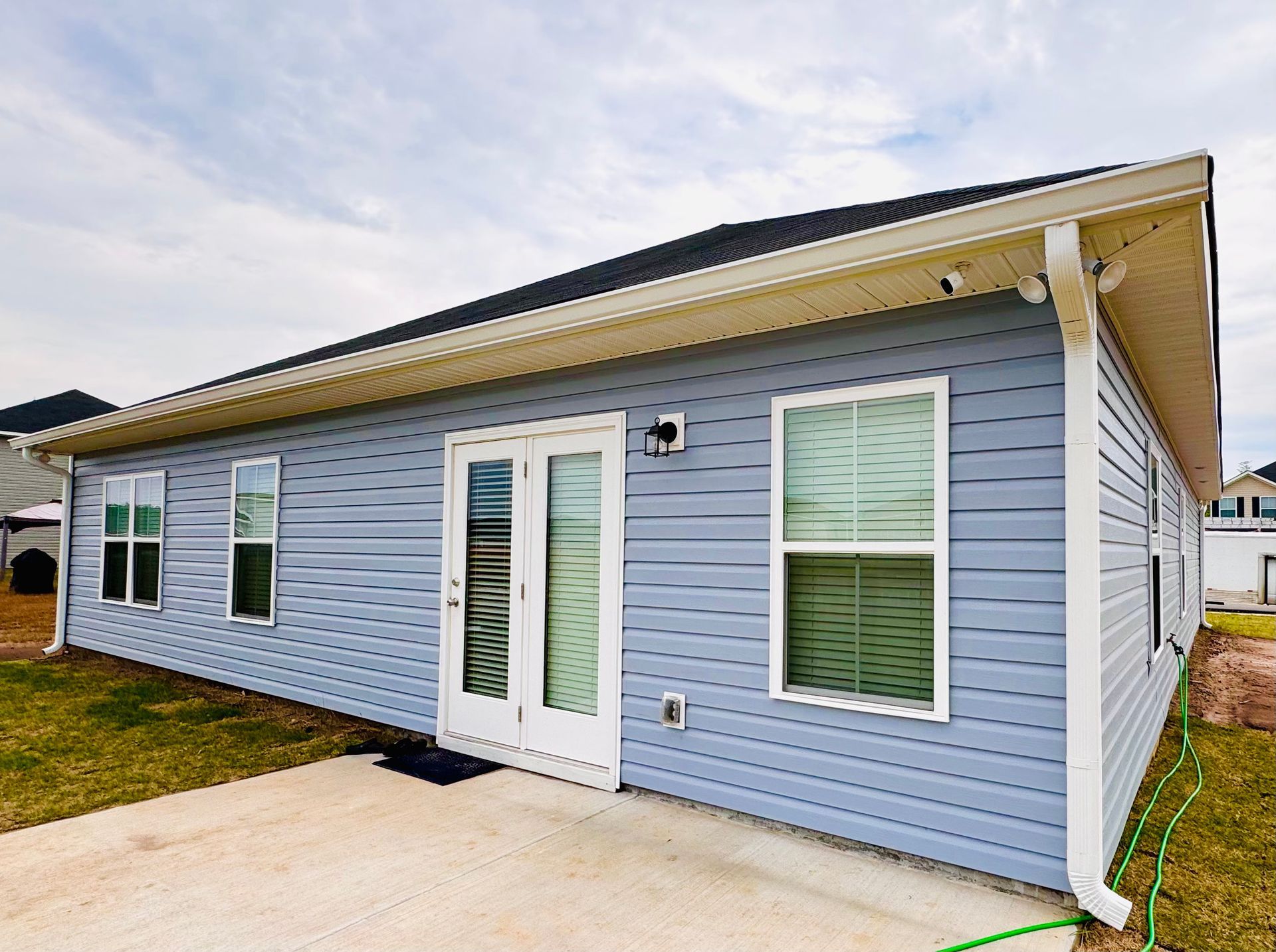 A small house with a blue siding and white trim