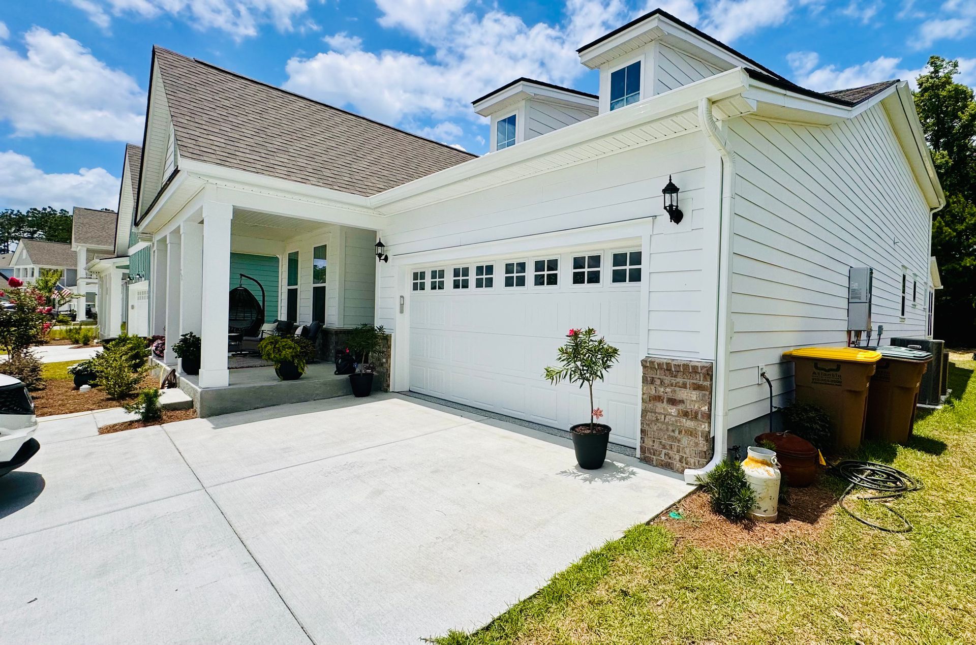A white house with a car parked in front of it.