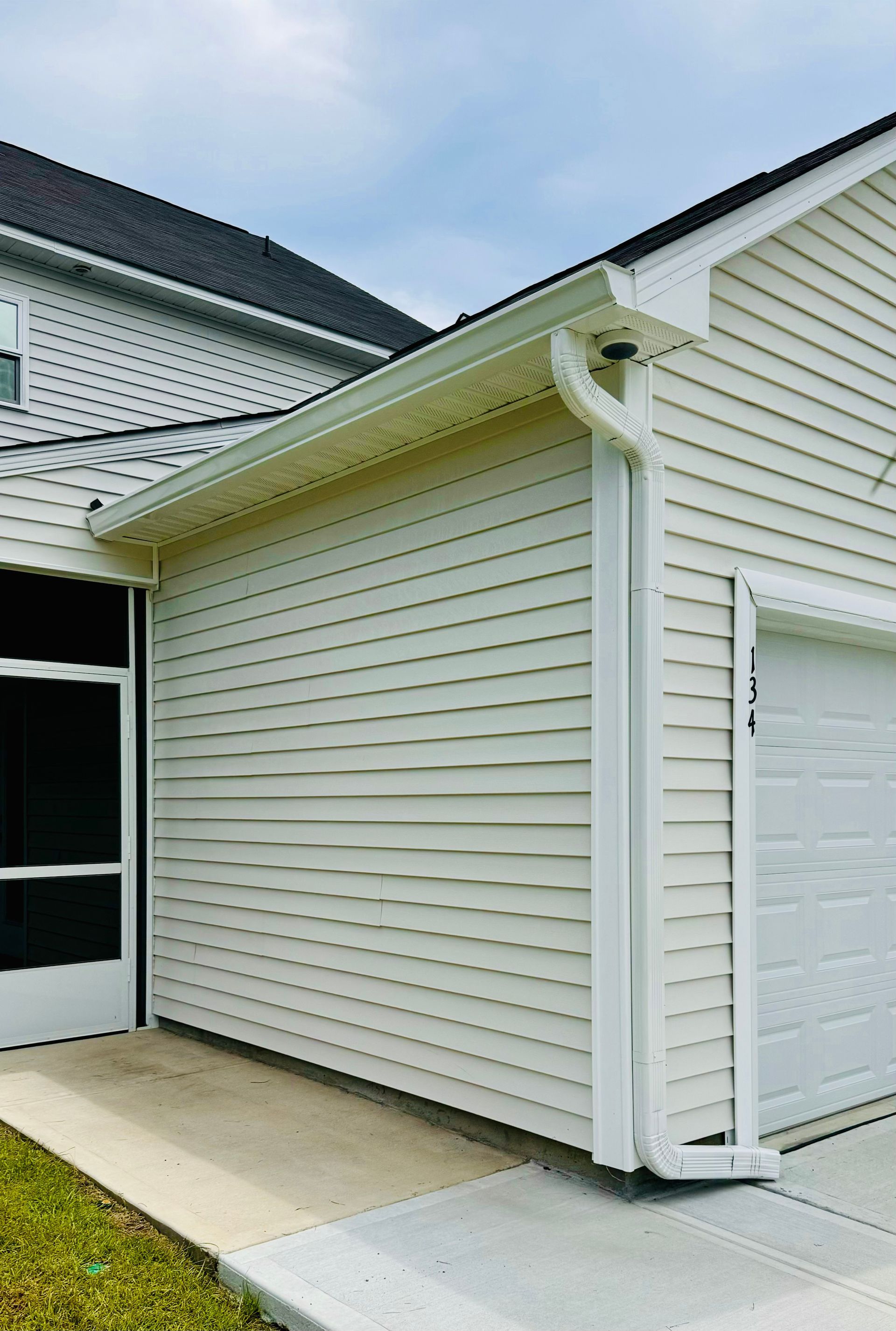 A white house with a garage and a black door.
