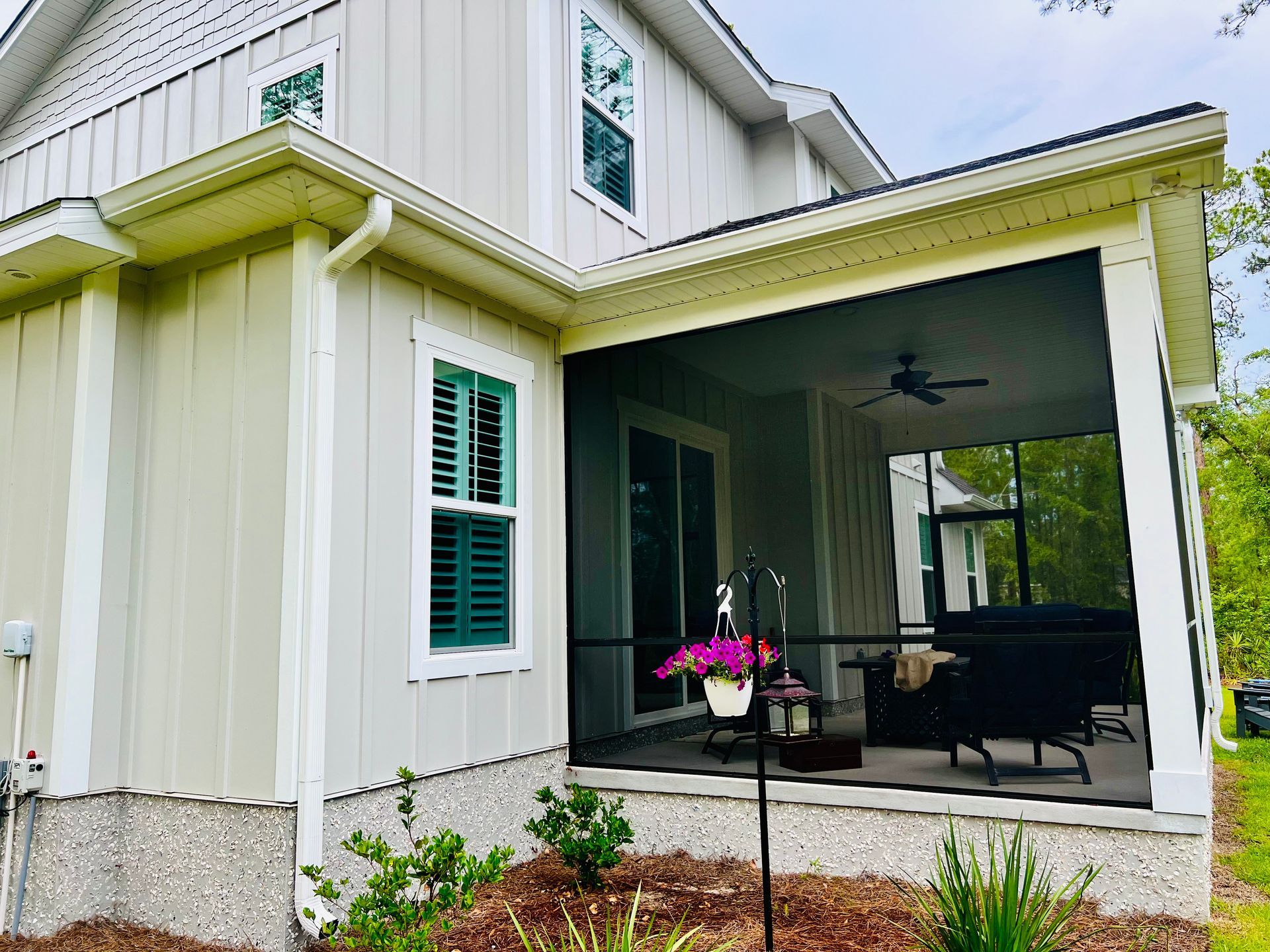 A house with a screened in porch and a ceiling fan.