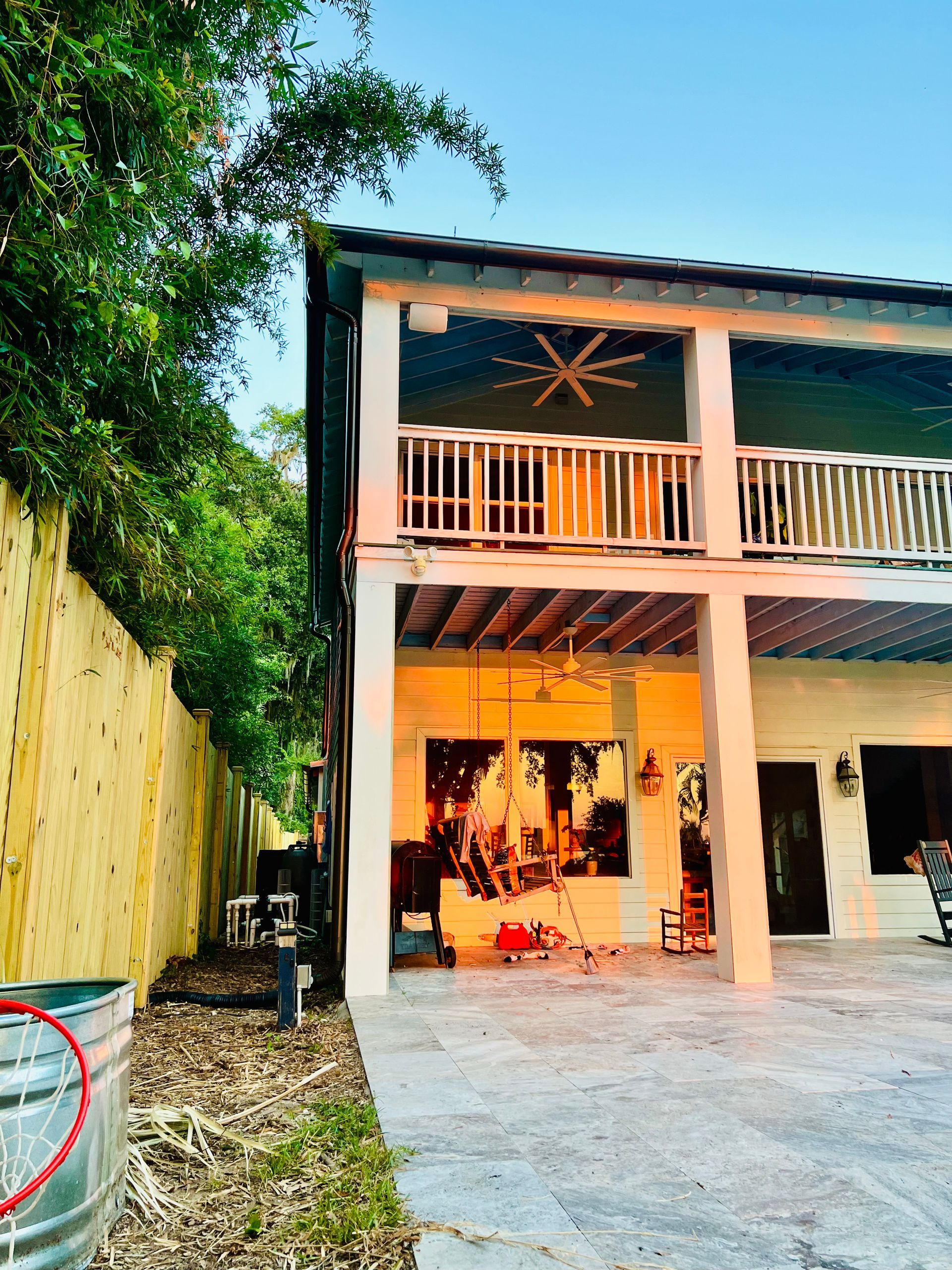 The back of a house with a balcony and a fence