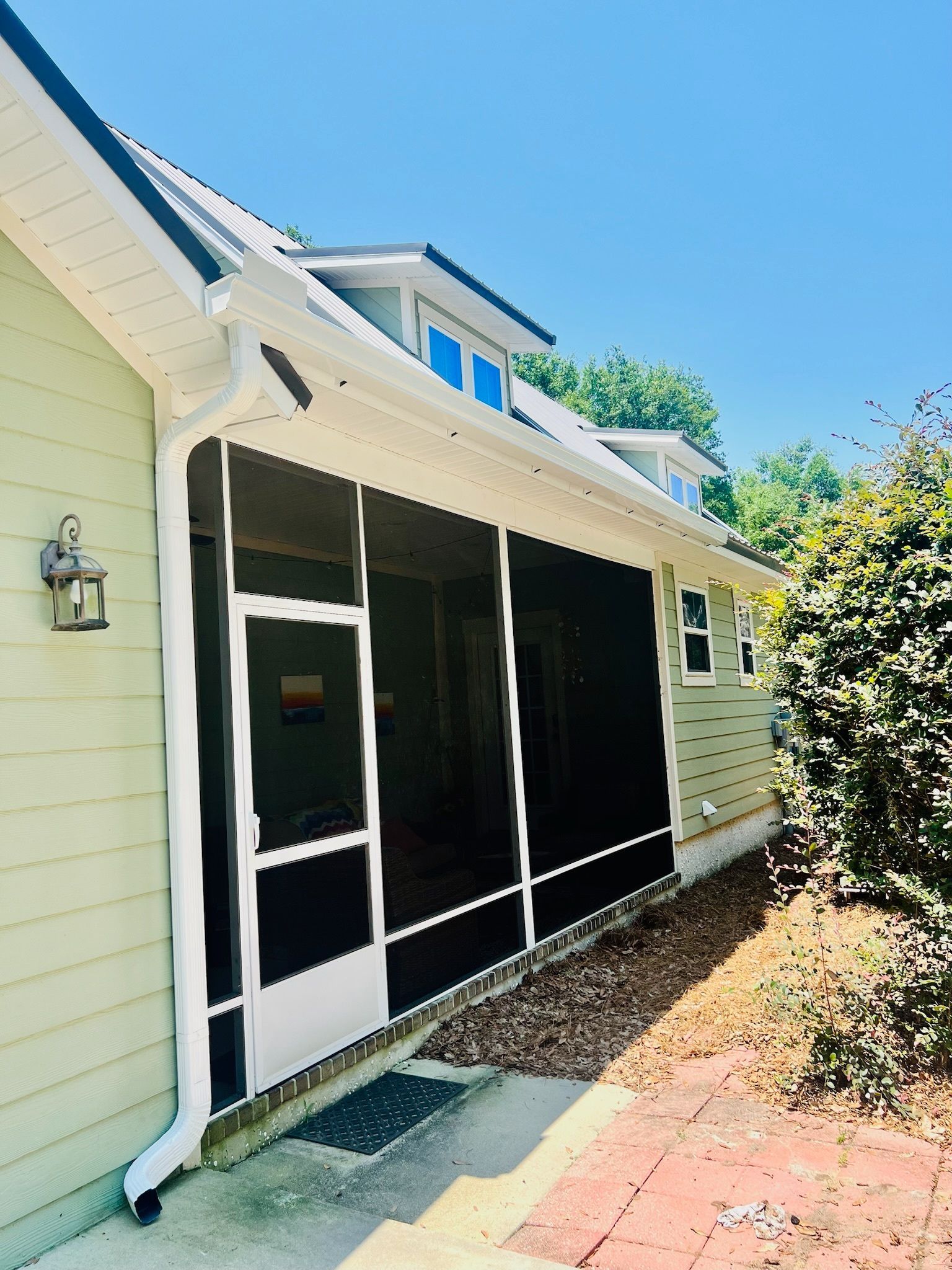 A screened in porch on the side of a house