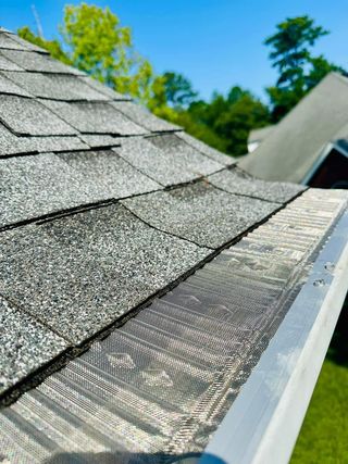 A close up of a gutter on the side of a house.