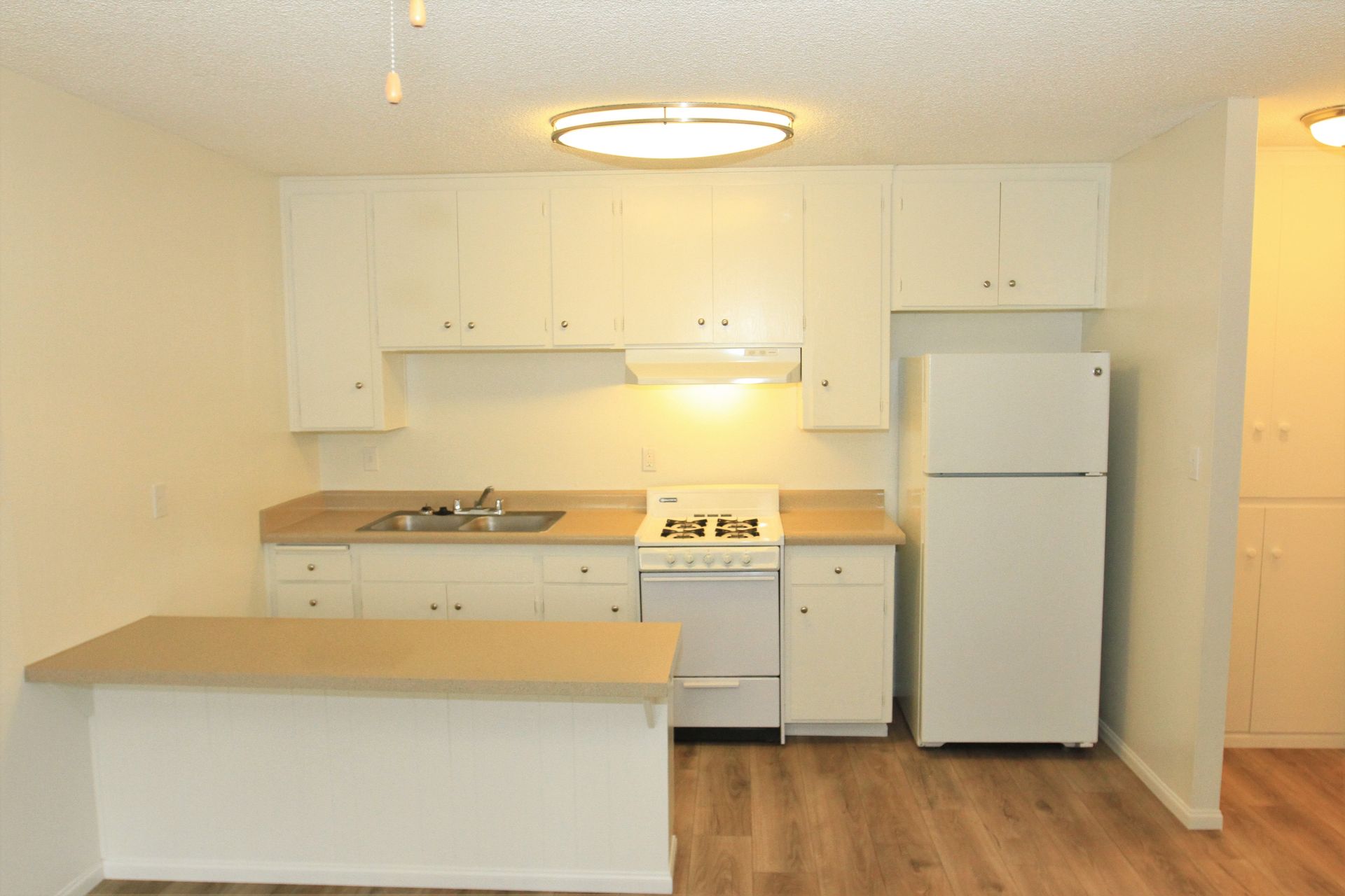 A kitchen with white cabinets and a white refrigerator