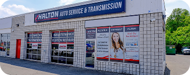 A white building with a red and black sign that says transmission | Halton Auto Service & Transmission