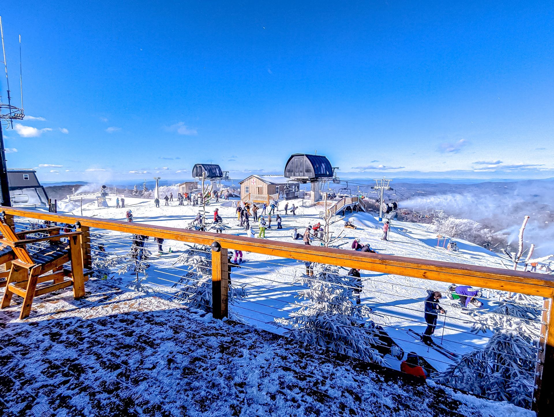 A view of a ski resort from the top of a snow covered mountain.