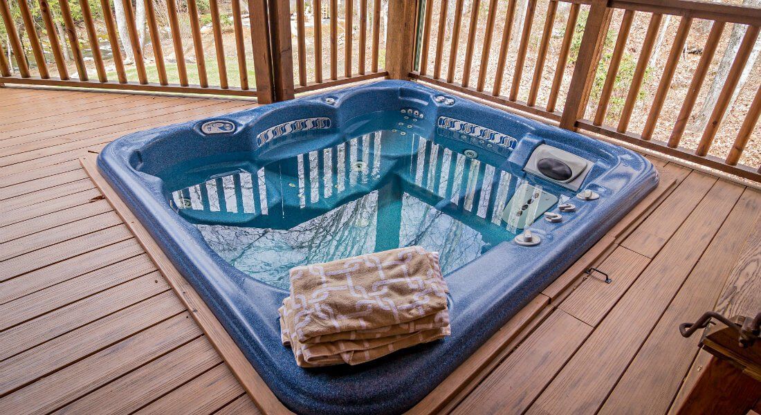 A hot tub is sitting on top of a wooden deck.