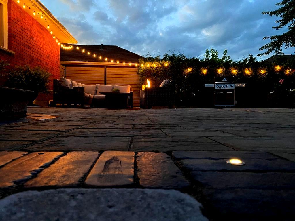 Outdoor patio with in-ground lighting, string lights, and seating, highlighting safe walkways