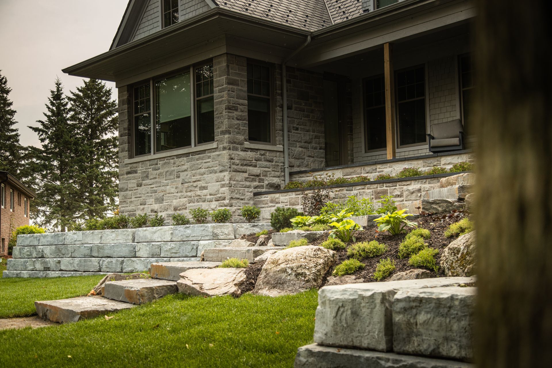 Stone house with tiered stonework steps and landscaping.