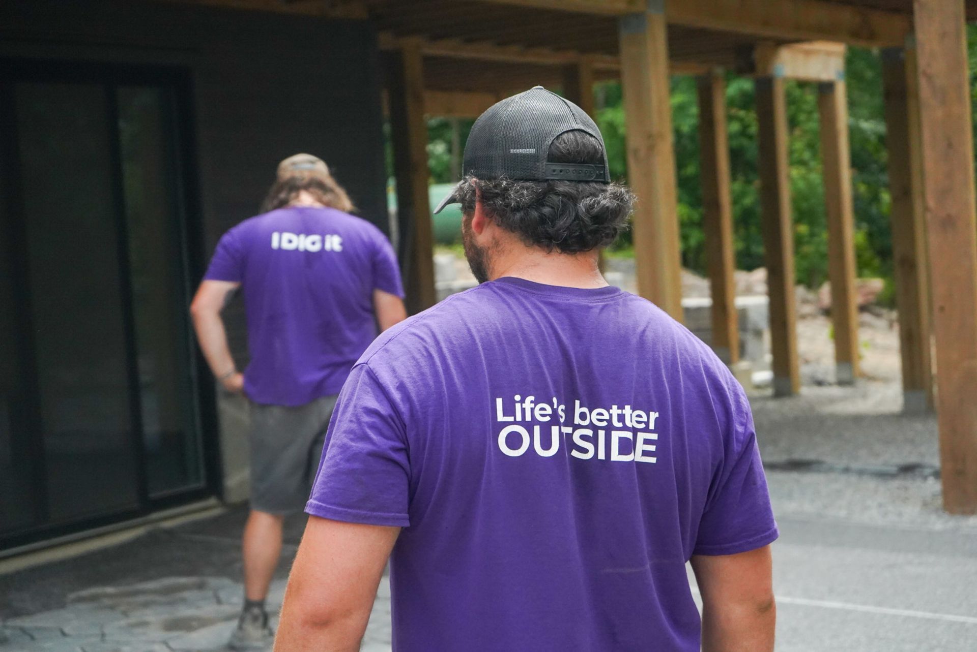 Two people in purple shirts with text 