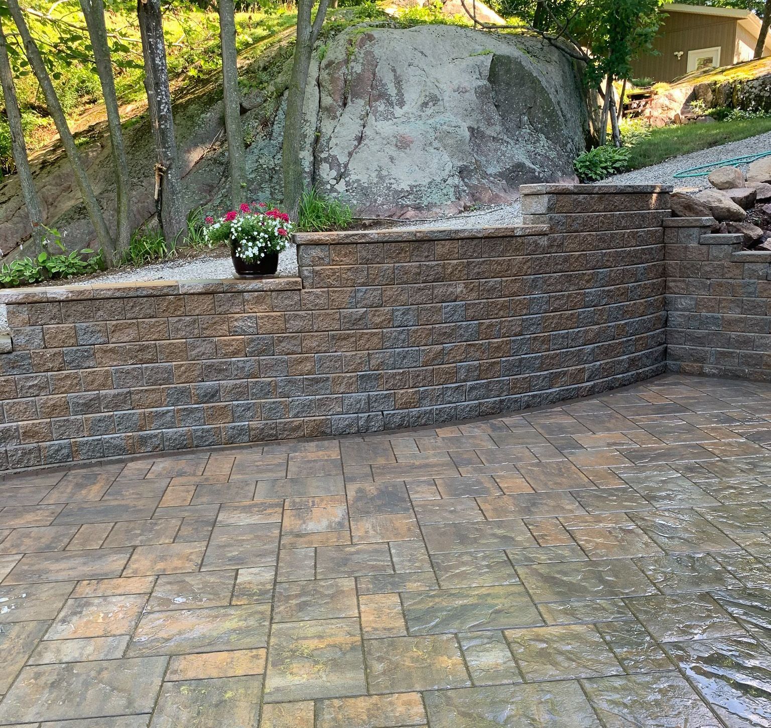 Curved interlock retaining wall with stone patio in Kingston backyard 