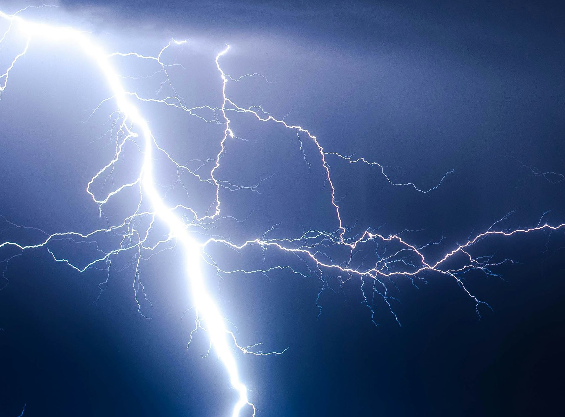 Lightning strike across a dark stormy sky, representing heavy spring rainfall.