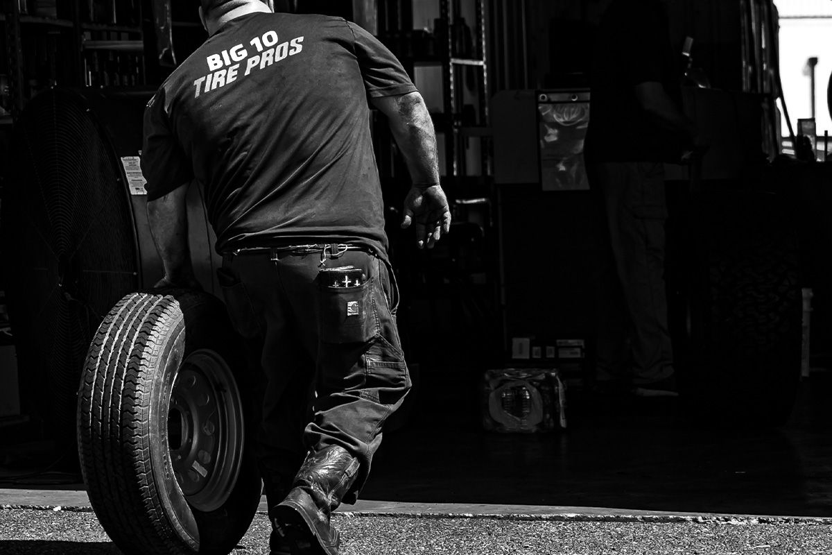 a man is pushing a tire in a black and white photo .