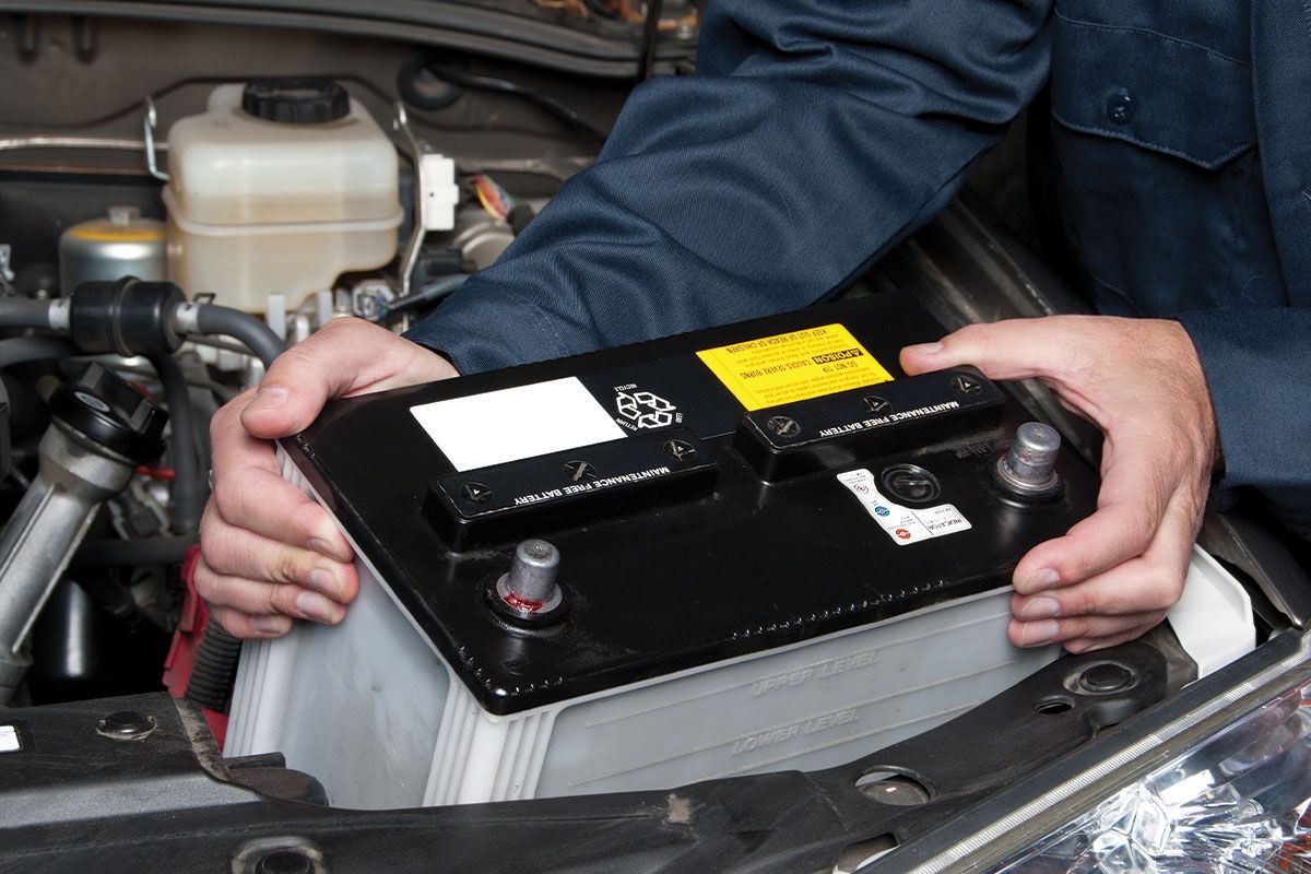 a person is holding a car battery in their hands