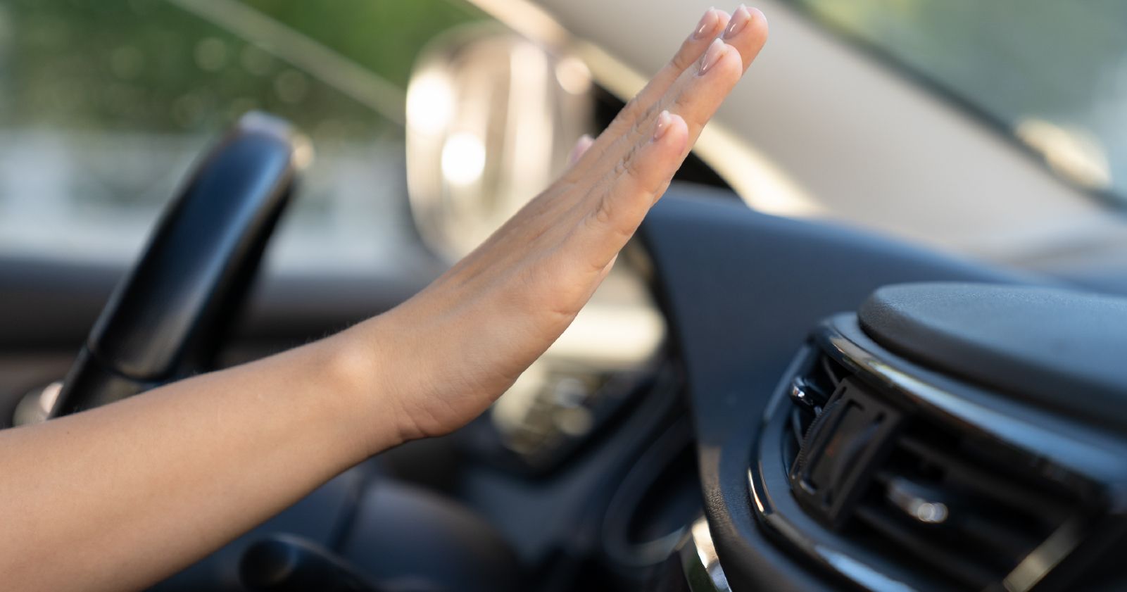 A woman is giving a high five while driving a car.