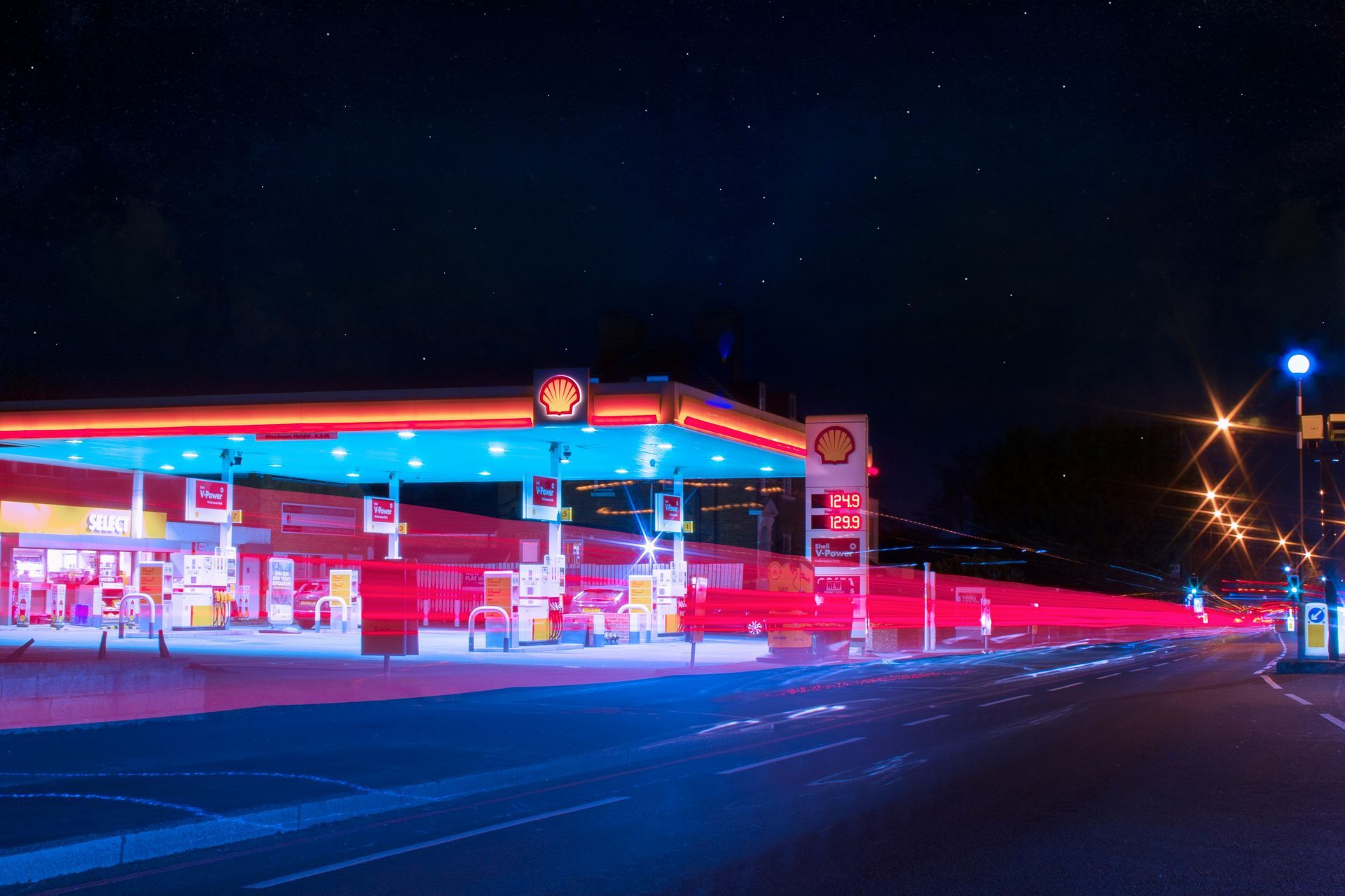 A gas station is lit up at night with a lot of lights.