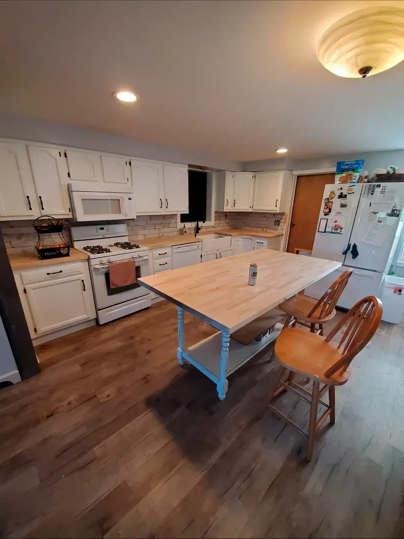 A kitchen with a table and chairs in it.