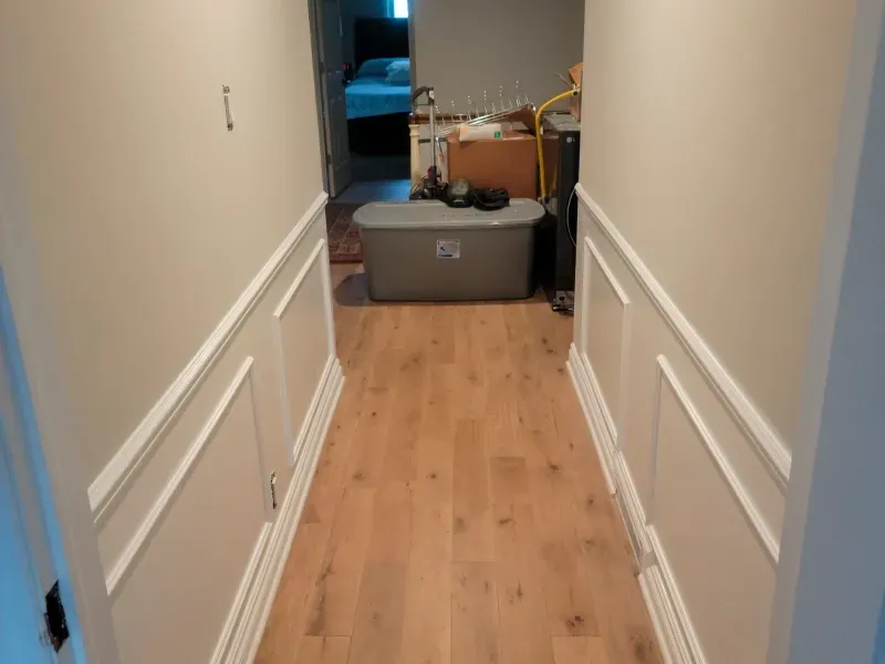 A long hallway with wooden floors and white trim