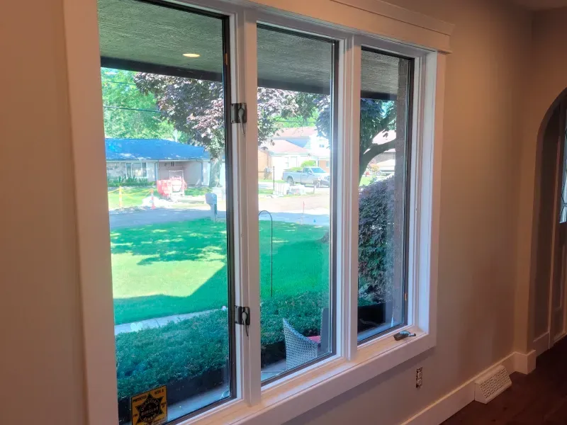 A large window in a room with a view of a yard.
