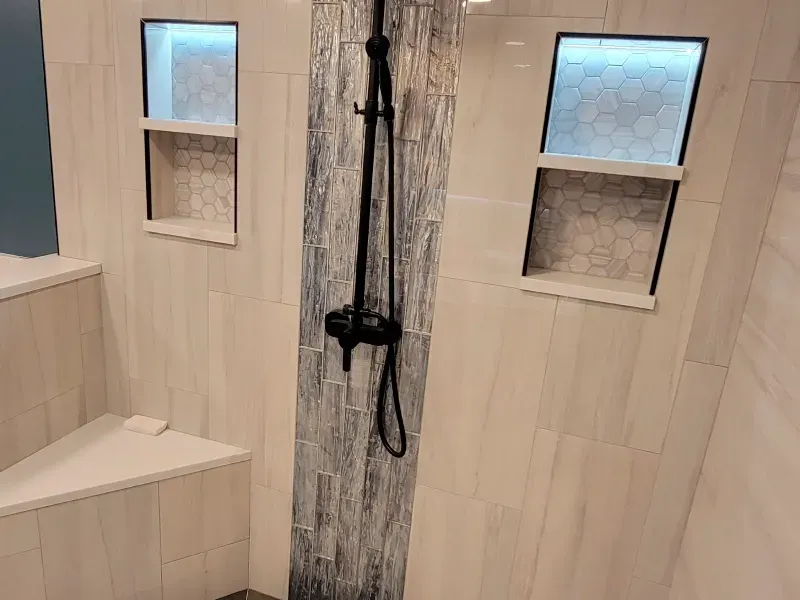 A bathroom with a walk in shower and a bench.