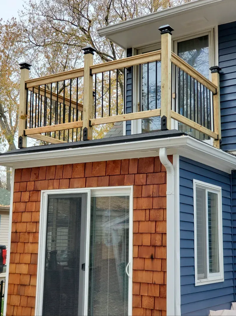 A blue house with a balcony on top of it