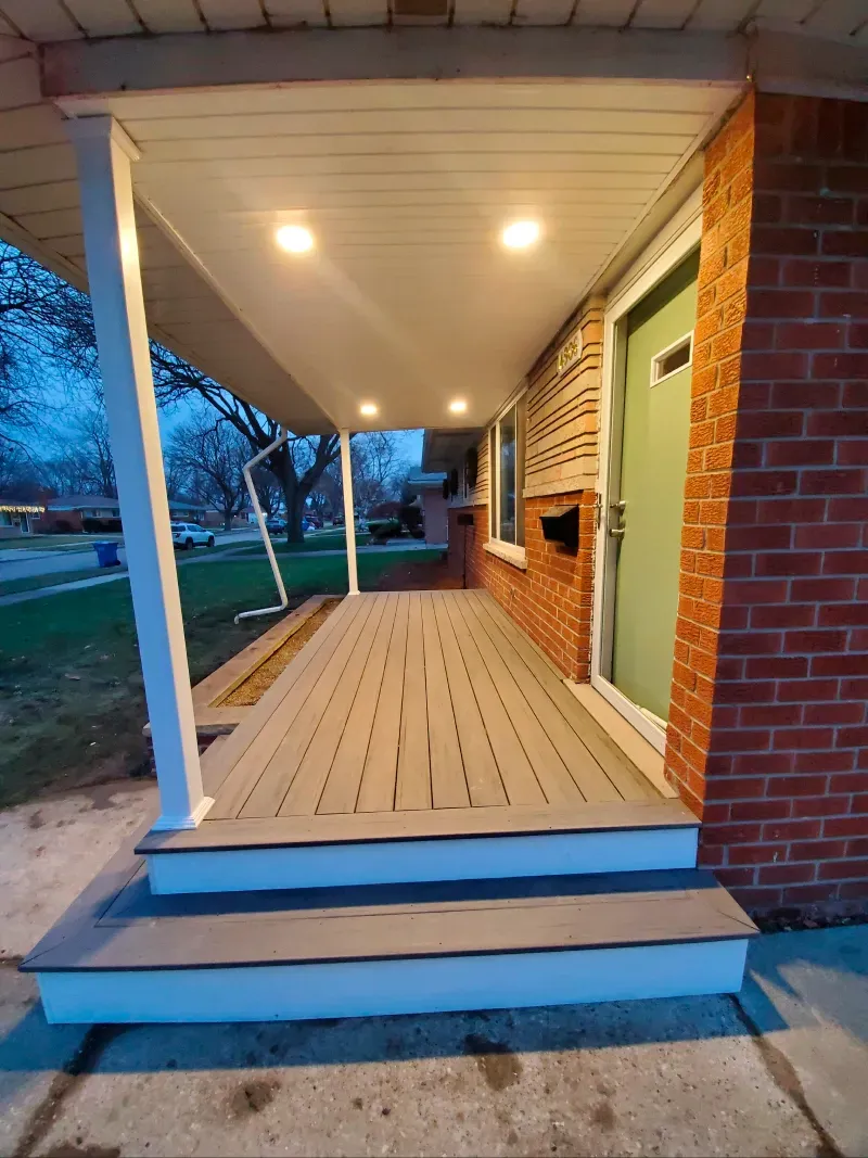 A brick house with a porch and a green door.