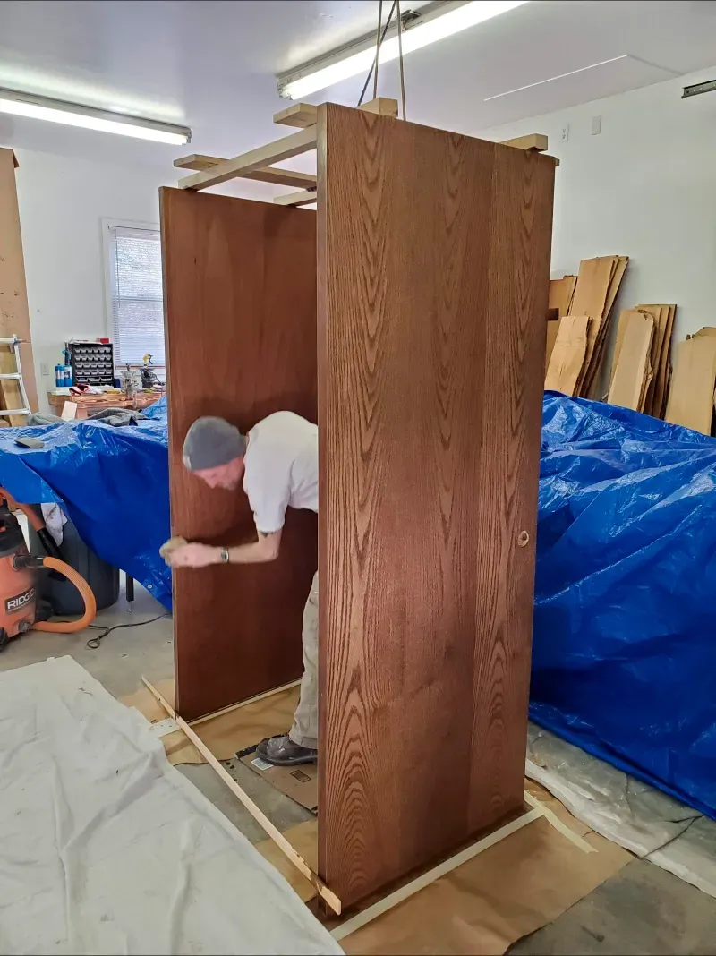 A man is working on a piece of wood in a workshop.