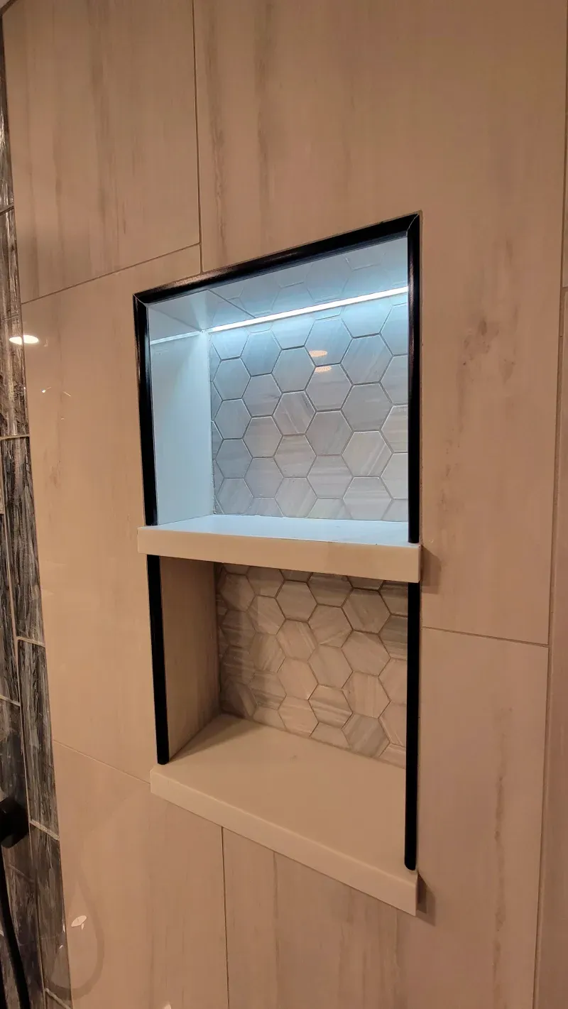 A shower niche with a light inside of it in a bathroom.