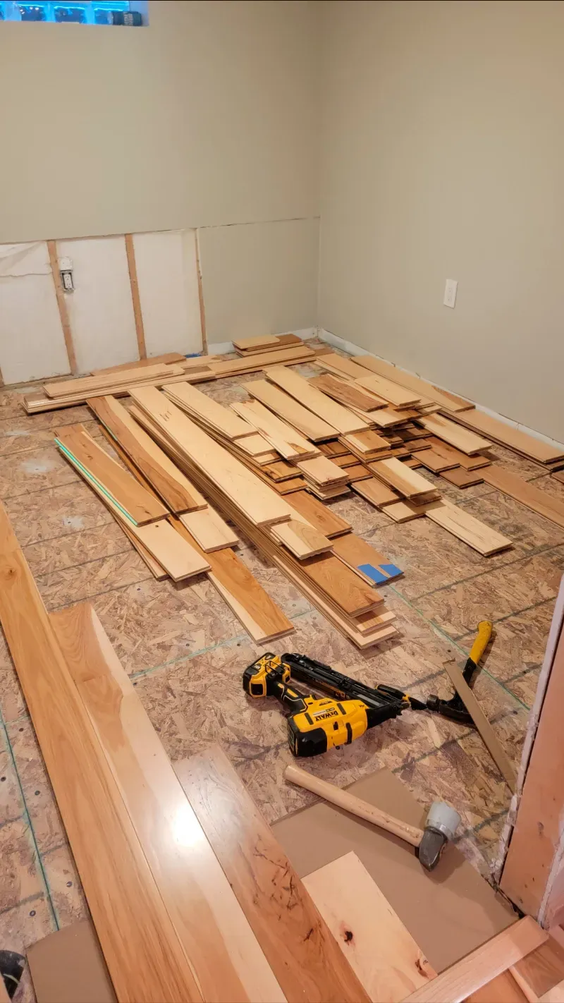 A room with a lot of wood and tools on the floor.