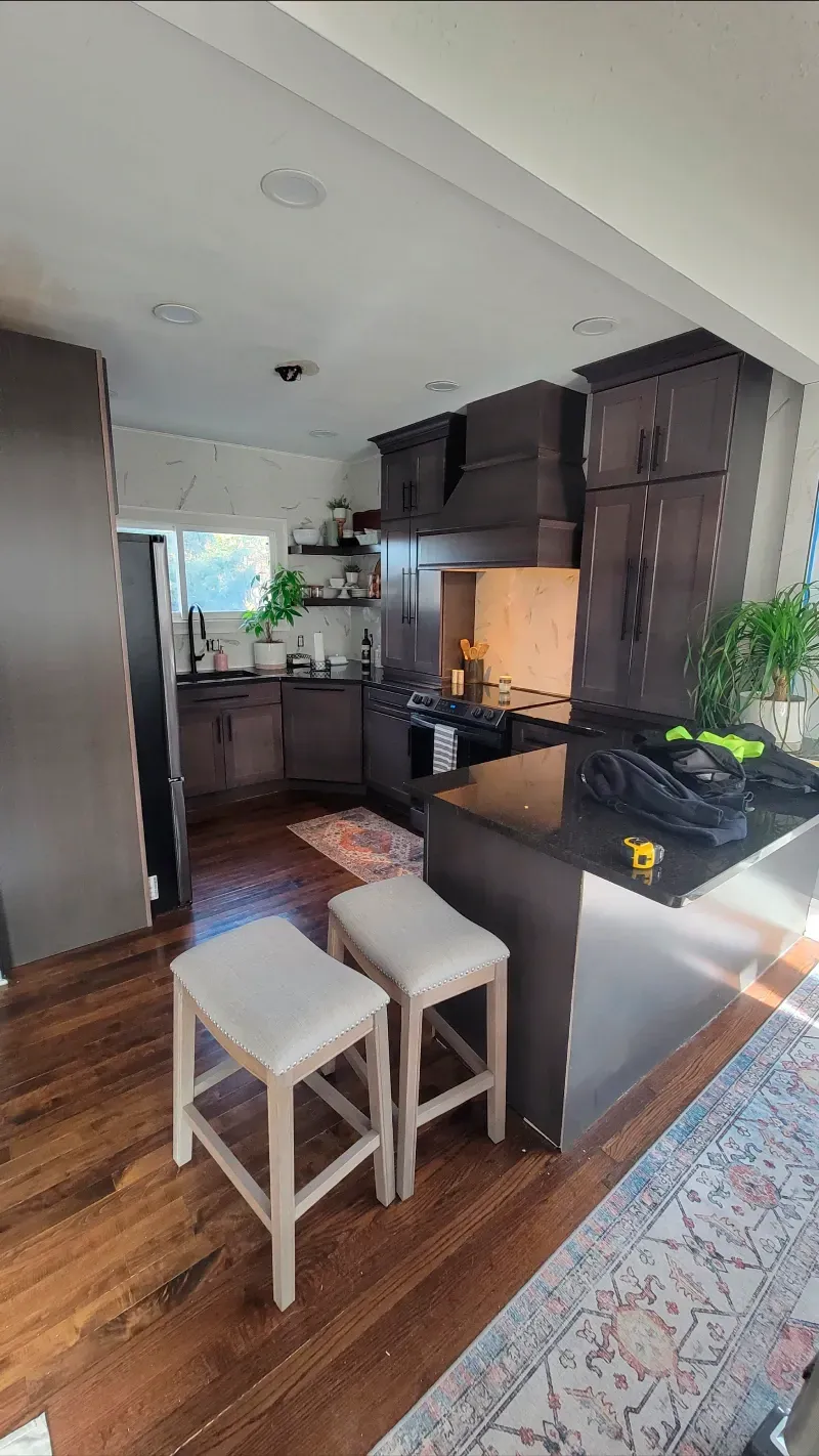 A kitchen with two stools and a rug on the floor.