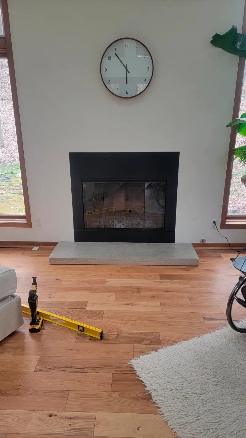A living room with a fireplace and a clock on the wall.