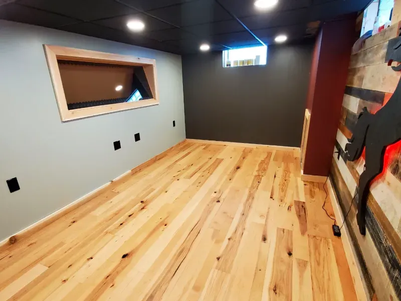 A room with a wooden floor and a window on the wall.
