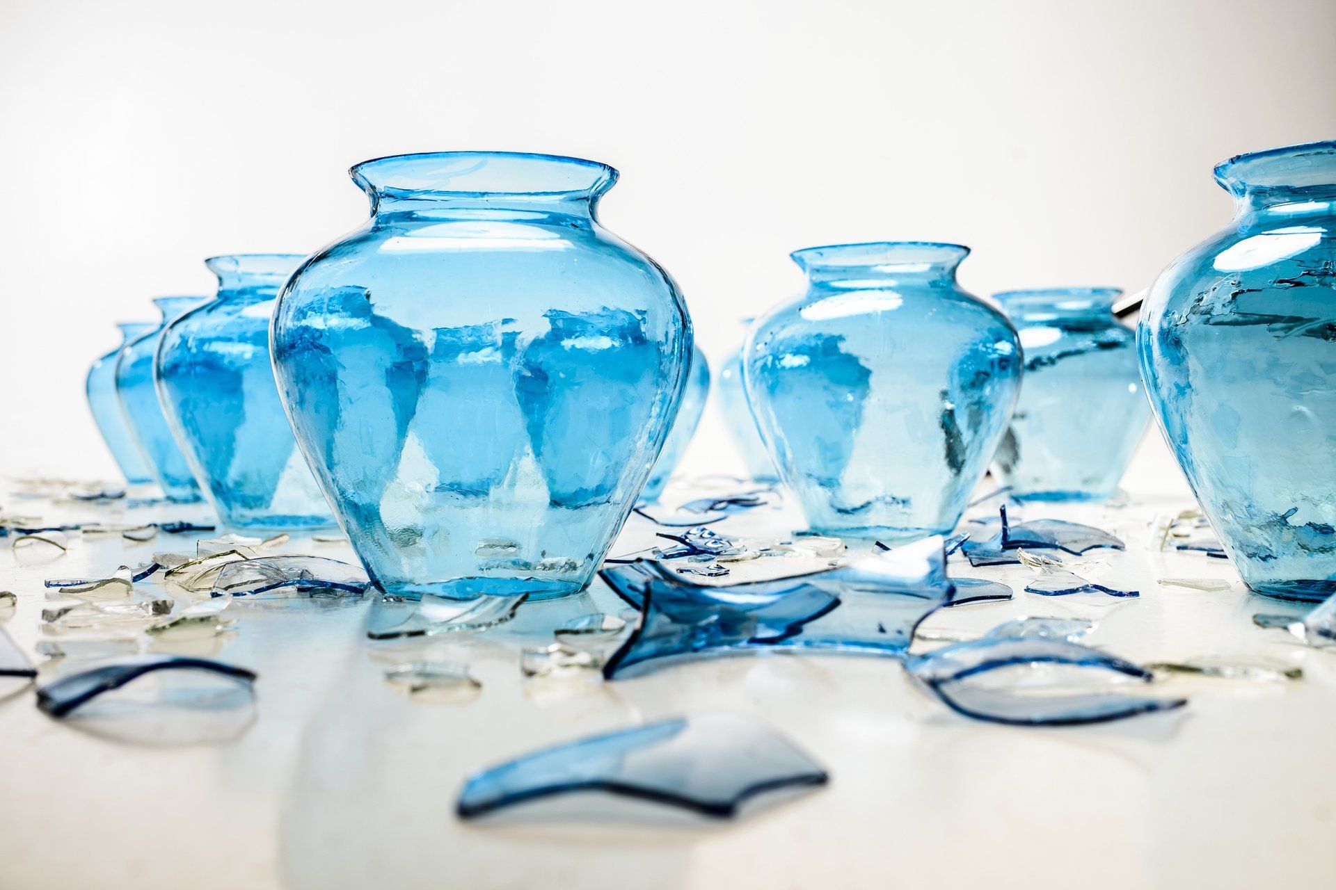 Photo of multiple blue vases with shattered glass symbolizing the Breaking Vases theme.