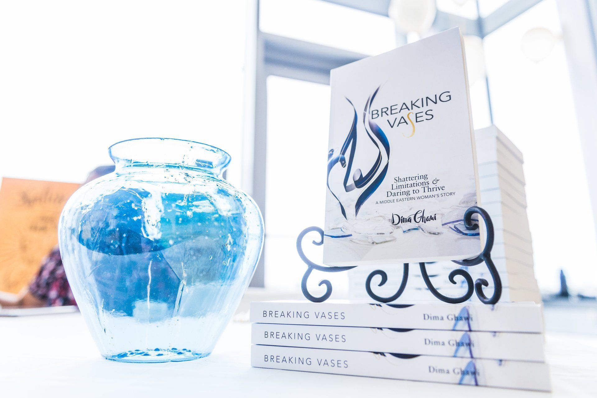 Photo of Dima Ghawi signing Breaking Vases books at an event.