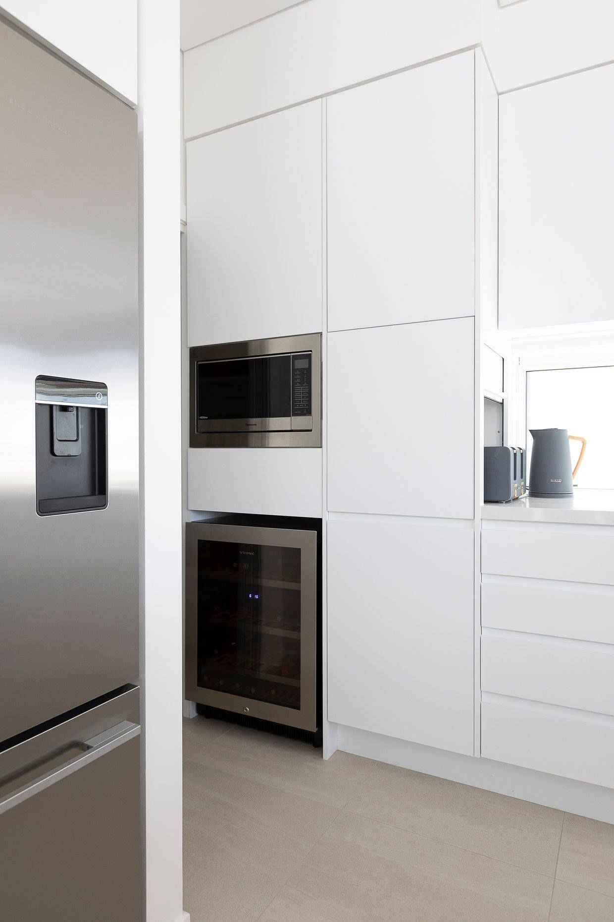 A Kitchen With Stainless Steel Appliances And White Cabinets — North Coast Cabinets In Ballina, NSW
