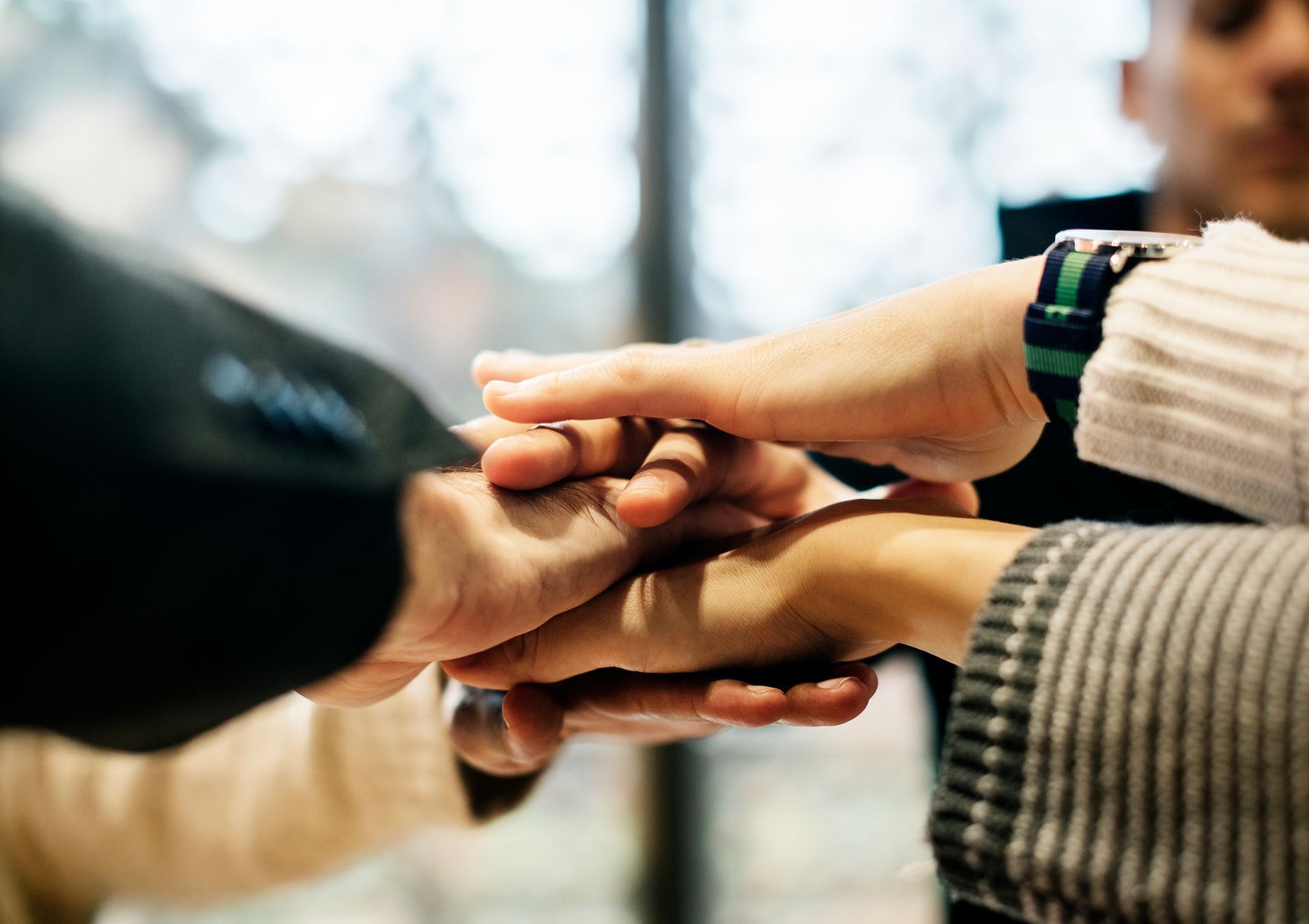 A group of people are putting their hands together.