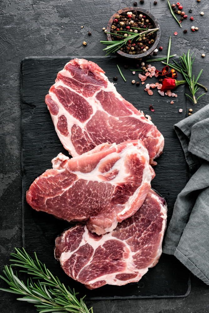 Raw Pork Chops On A Cutting Board With Spices — Wattle Butchery In Cootamundra, NSW